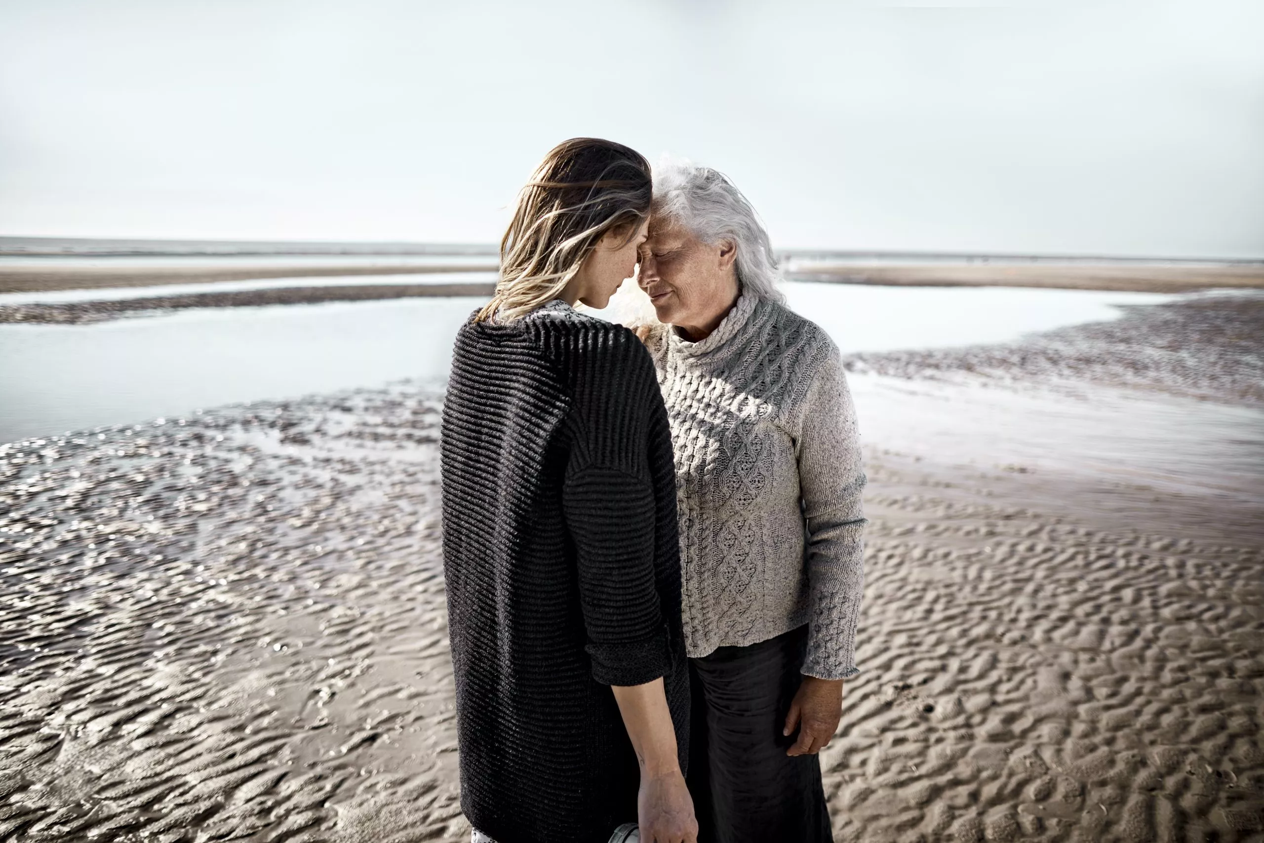 Ältere Frau mit ihrer erwachsenen Tochter am Strand